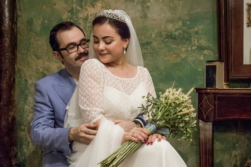 Fotografía de bodas en Marbella. La novia sentada sobre el novio con una ramo de flores