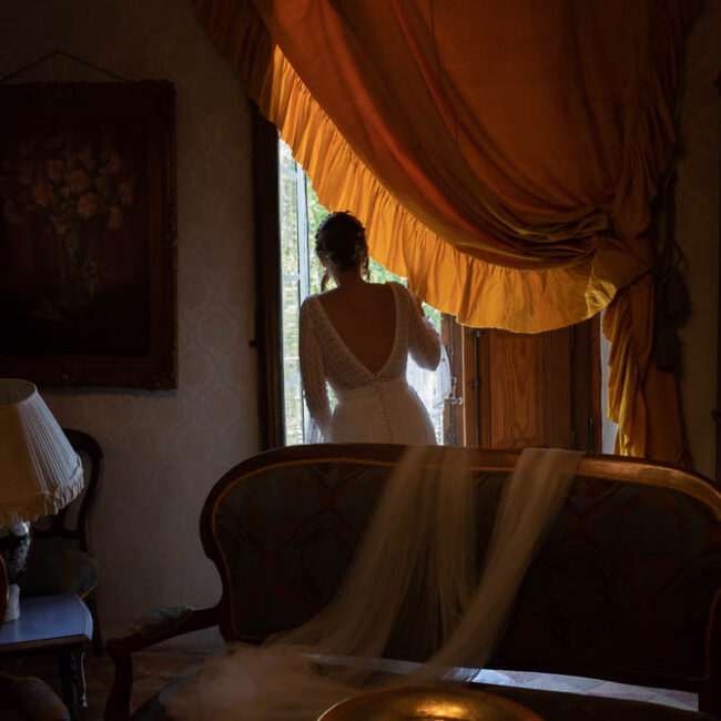 Novia mirando por la ventana durante fotografía de bodas en Jerez de la frontera, Cádiz